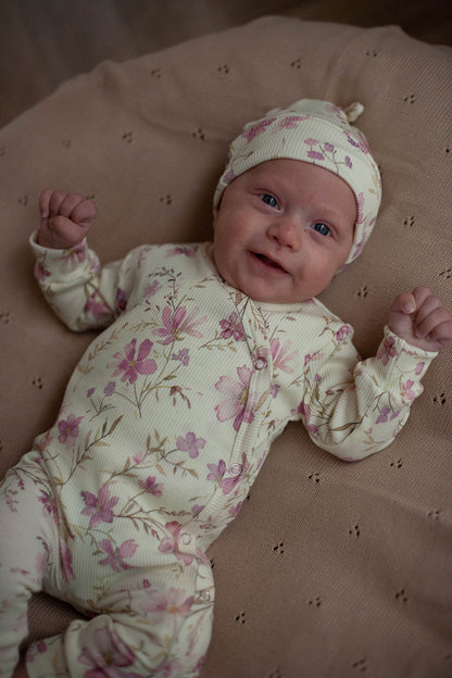Babystrampler im Rippenmuster, pastellgelb mit lila Blumen